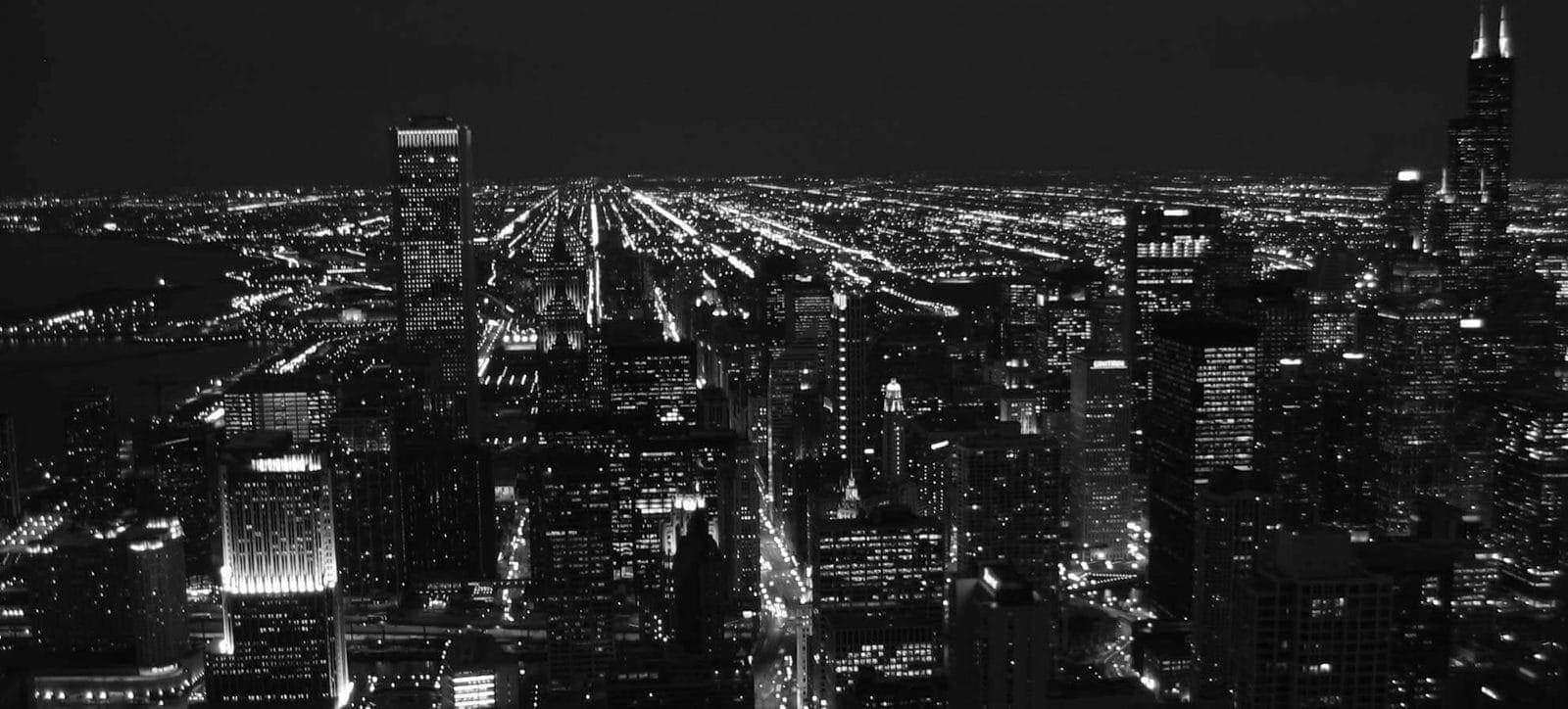 Gece aydınlanmış küçük işletmeler ve dükkanların bulunduğu bir cadde